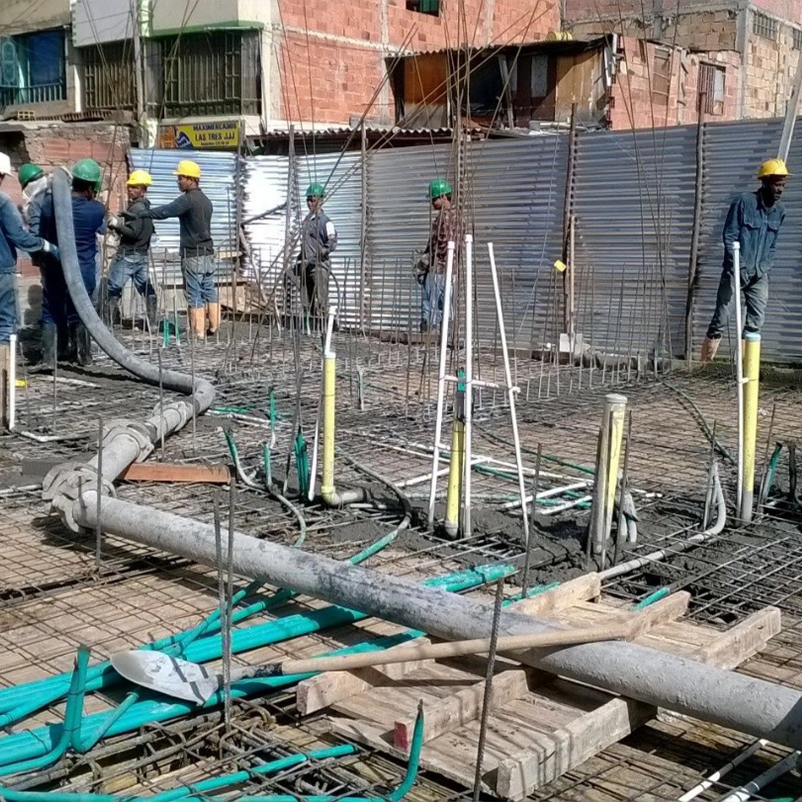 Fundida de una placa: la cuadrilla vierte el concreto bombeado sobre la parrilla de refuerzo y las redes ya dispuestas.